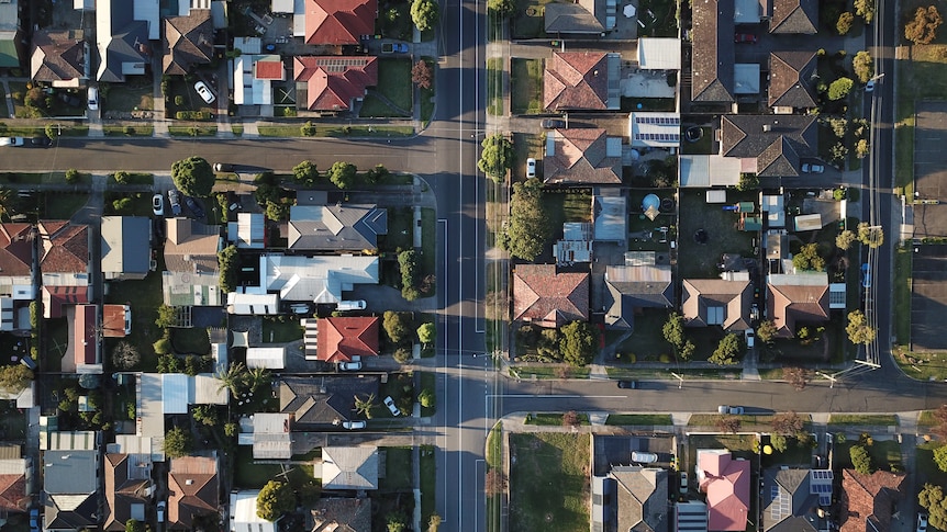 Drone view of housing rooftops and roads