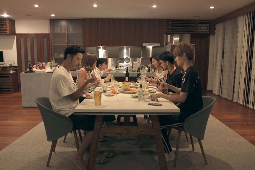 A group of young Japanese people eating dinner together in a sharehouse in the show Terrace House