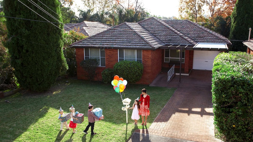 Children with presents arrive at a brick house with presents.