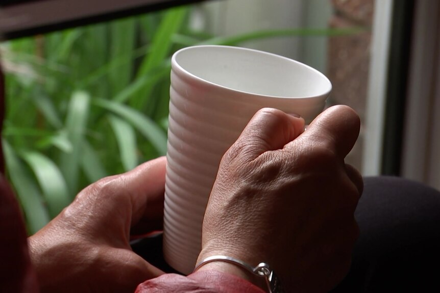 A person holding a mug.