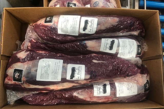 Packaged cuts of beef with Four Daughters branding in a cardboard box.