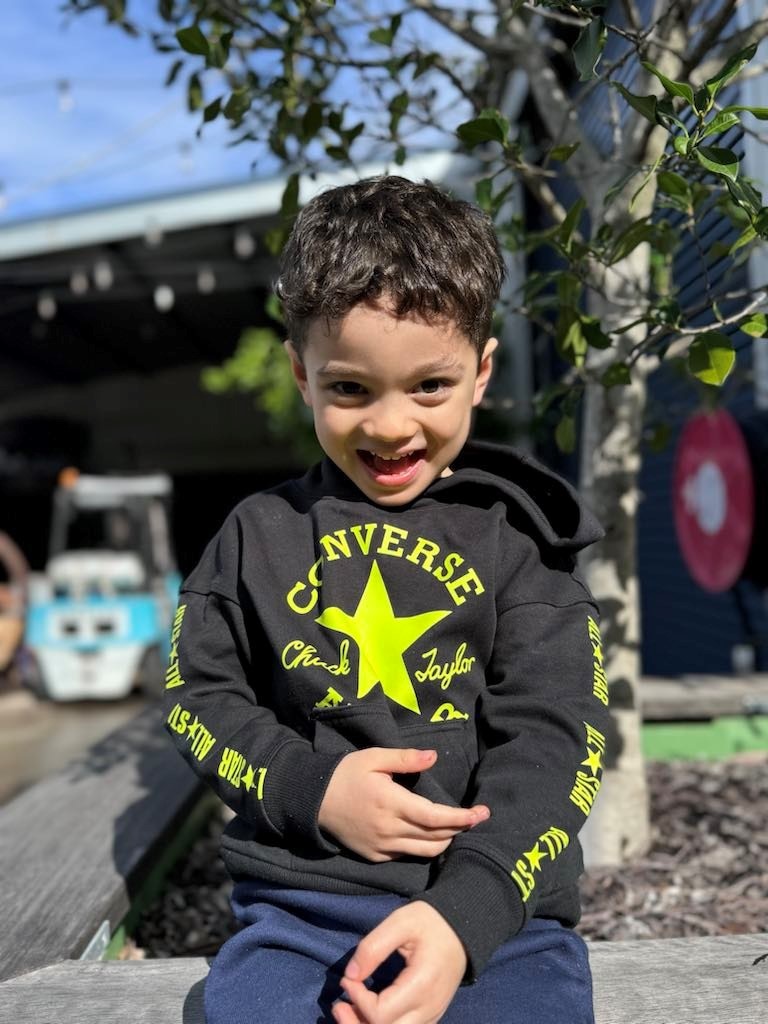 A four year old boy with a cheeky smile.