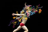 A shirtless dancer collides with a bundle of woolen props 