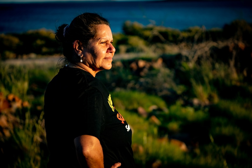 Raelene Cooper looks out  to the peninsula with her hands on her hips.