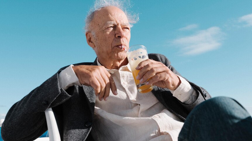 Peter Singer having a drink on the beach