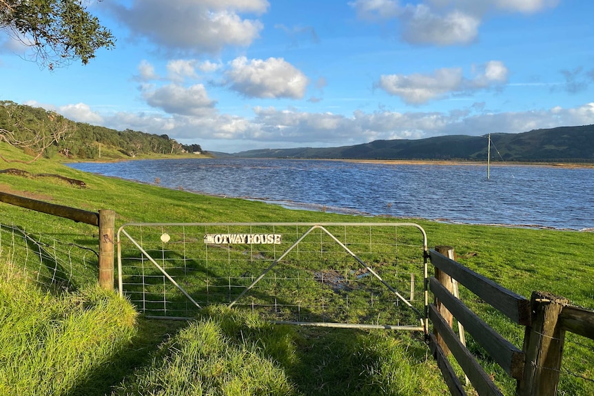 A gate in front of a flooded pasture paddock.