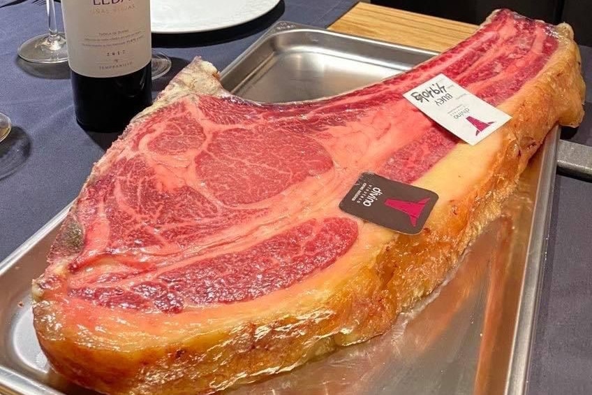 a very large uncooked t-bone steak on a tray