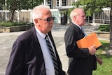 Peter Cuzman leaves court with his lawyers.