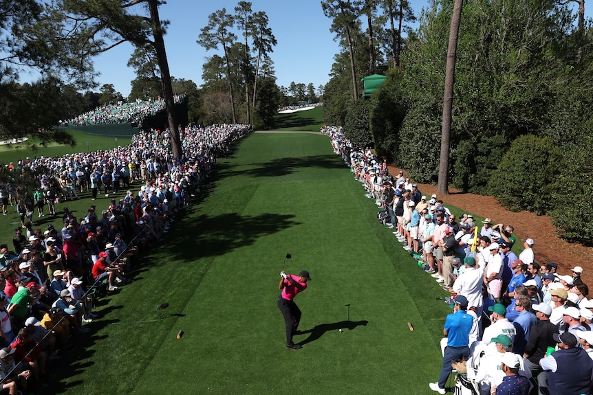 A golfer strikes a ball down the fairway 