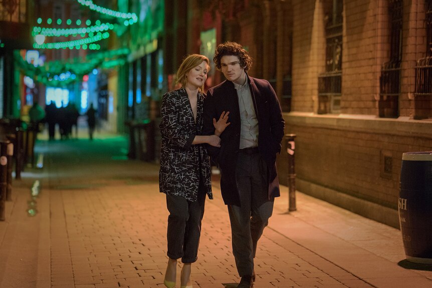 Holliday Grainger and Fra Fee walk down a street.