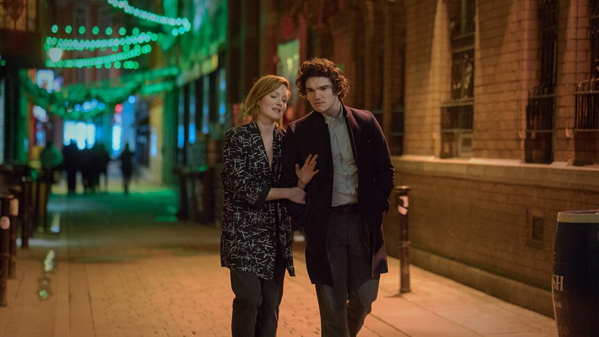 Holliday Grainger and Fra Fee walk down a street.