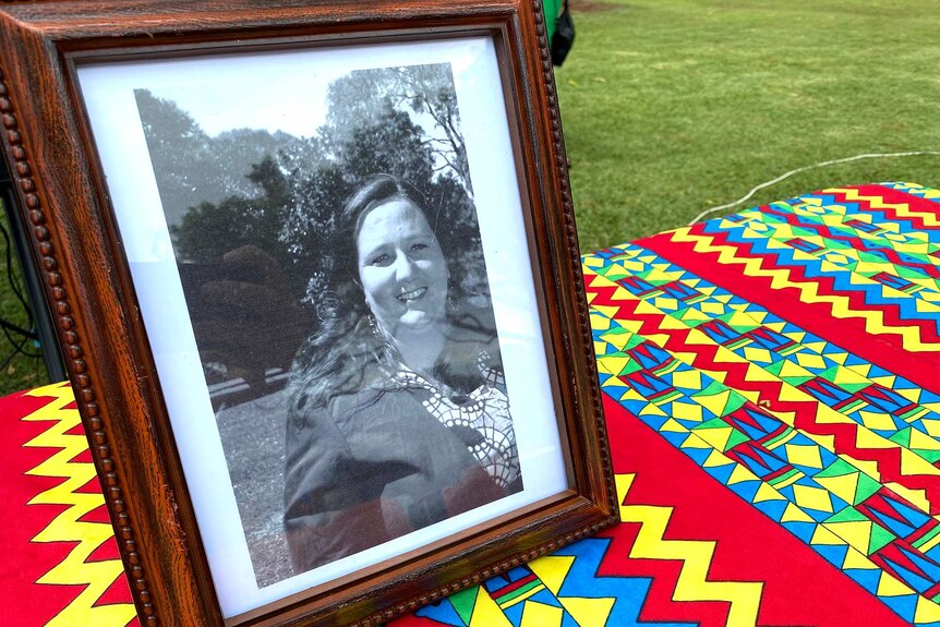 A framed photo of Cherie Martin placed on a table covered by colourful African fabric