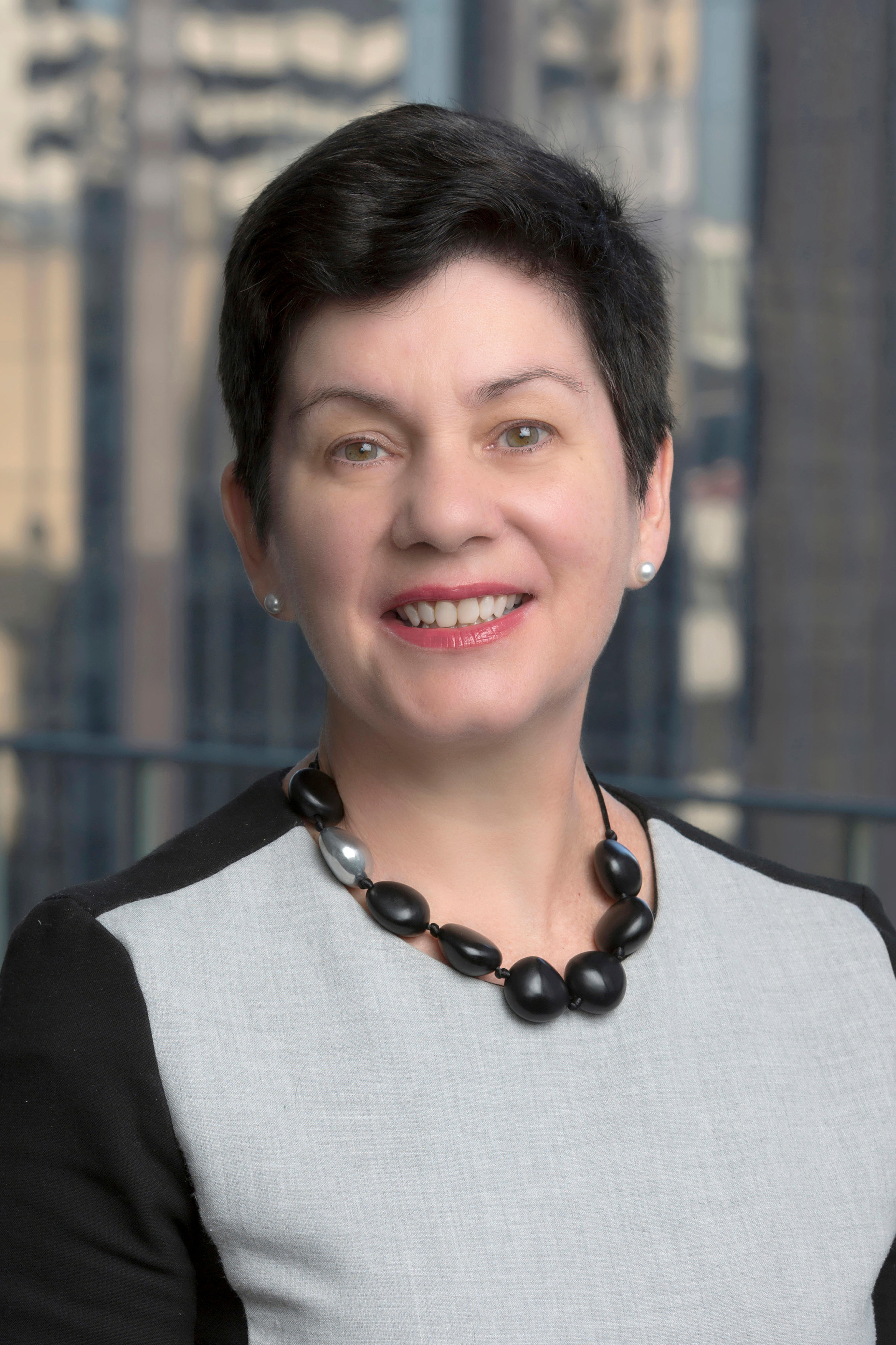 Middle age woman with short hair smiles at camera 