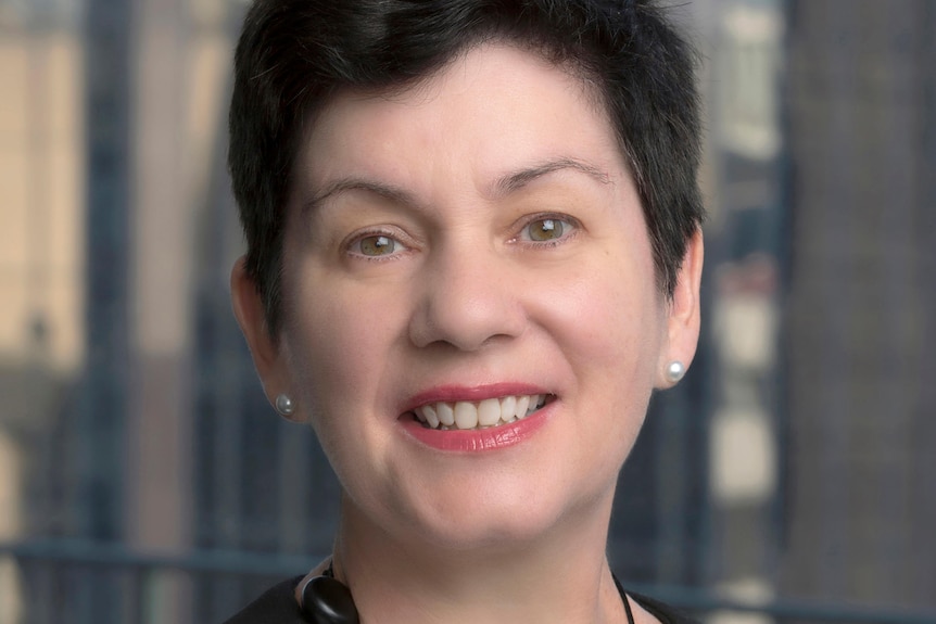 Middle age woman with short hair smiles at camera 