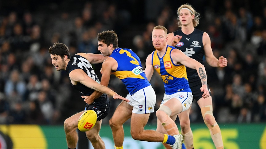 Two Carlton and two West Coast AFL players look to move towards the ball after a centre bounce.