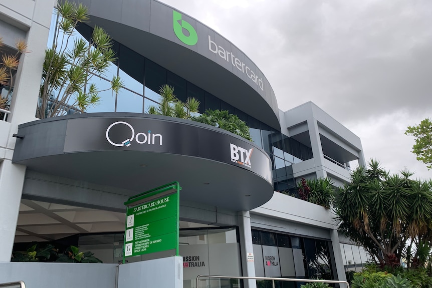 An office building with "Qoin" and BTX" emblazoned on the curving facade.
