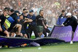 Fans invade the pitch during the Melbourne derby