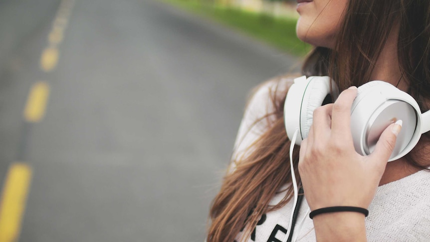 A woman with headphone around her neck.