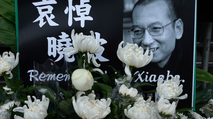 A portrait of late Chinese dissident Liu Xiaobo is displayed and surrounded by white flowers.