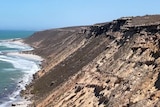 Cliffs meet the waters edge in an arid setting