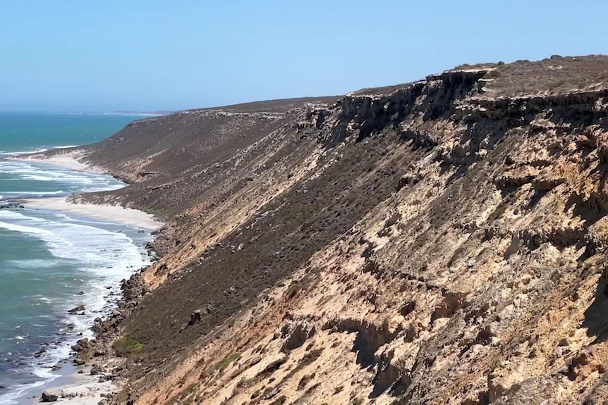 Cliffs meet the waters edge in an arid setting