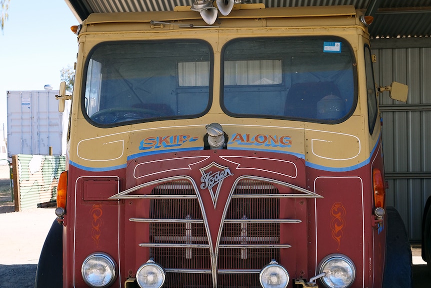 A red and yellow old British truck with 'skip along' written on the front