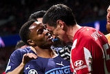Players from Atletico Madrid and Manchester City scuffle during a Champions League game.