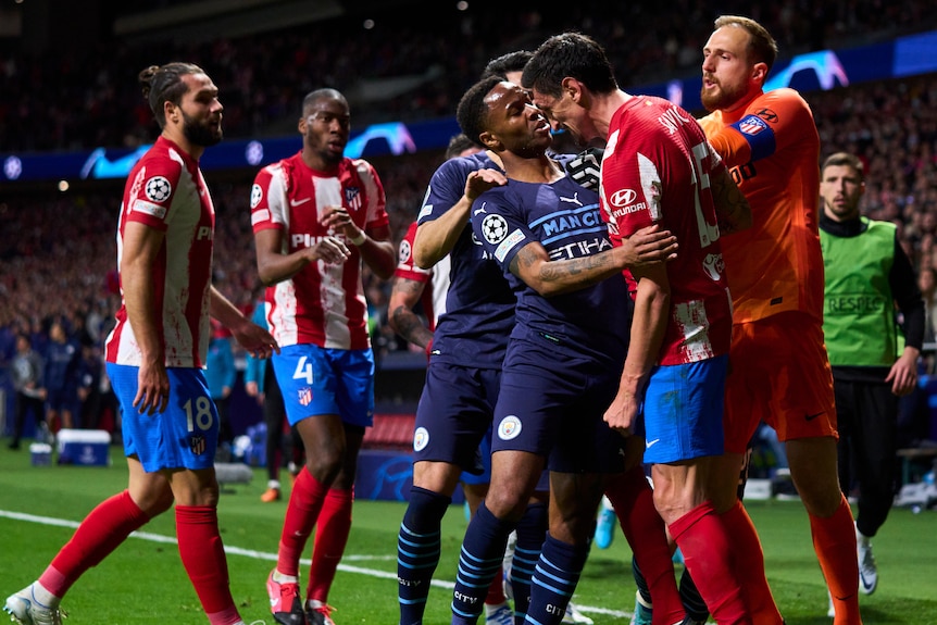 Players from Atletico Madrid and Manchester City scuffle during a Champions League game.
