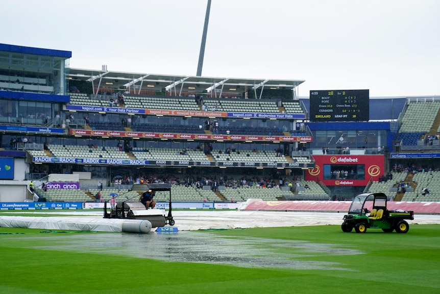 Groundskeepers work on a wet Edgbaston field during the first Ashes Test.
