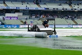 Groundskeepers work on a wet Edgbaston field during the first Ashes Test.