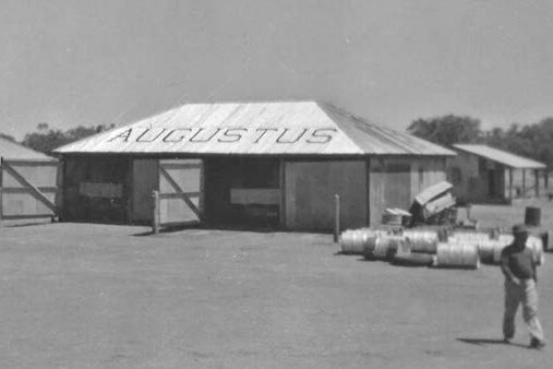 An old black and white image of Augustus station's shed housing two station vehicles.