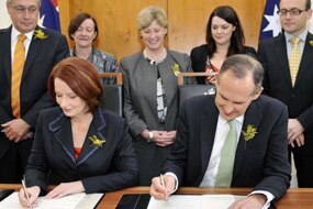 Julia Gillard and Bob Brown sign agreement (AAP: Alan Porritt)