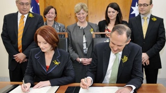 Julia Gillard and Bob Brown sign agreement (AAP: Alan Porritt)