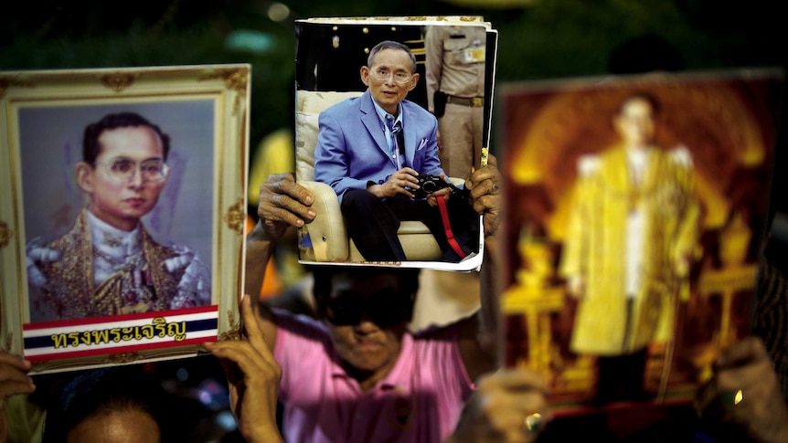 Well-wishers hold pictures of Thailand's King Bhumibol Adulyadej.