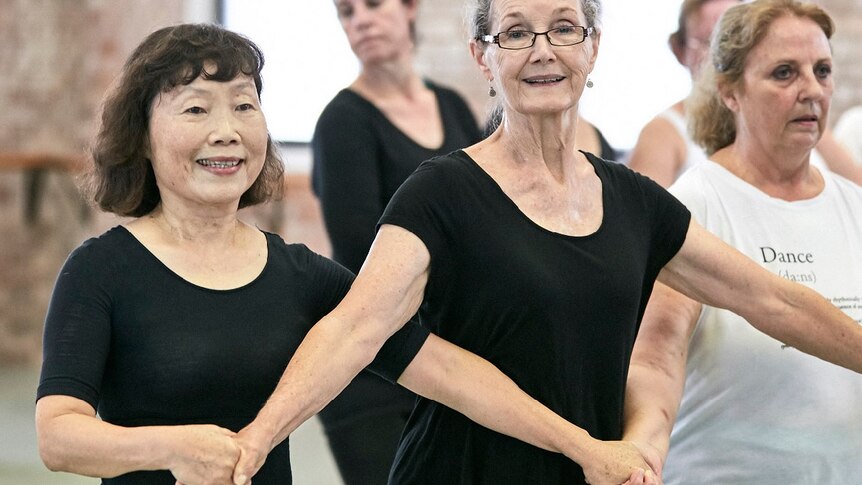 women holding hands at seniors ballet class at Queensland Ballet