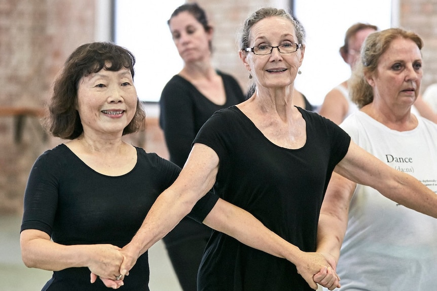 women holding hands at seniors ballet class at Queensland Ballet