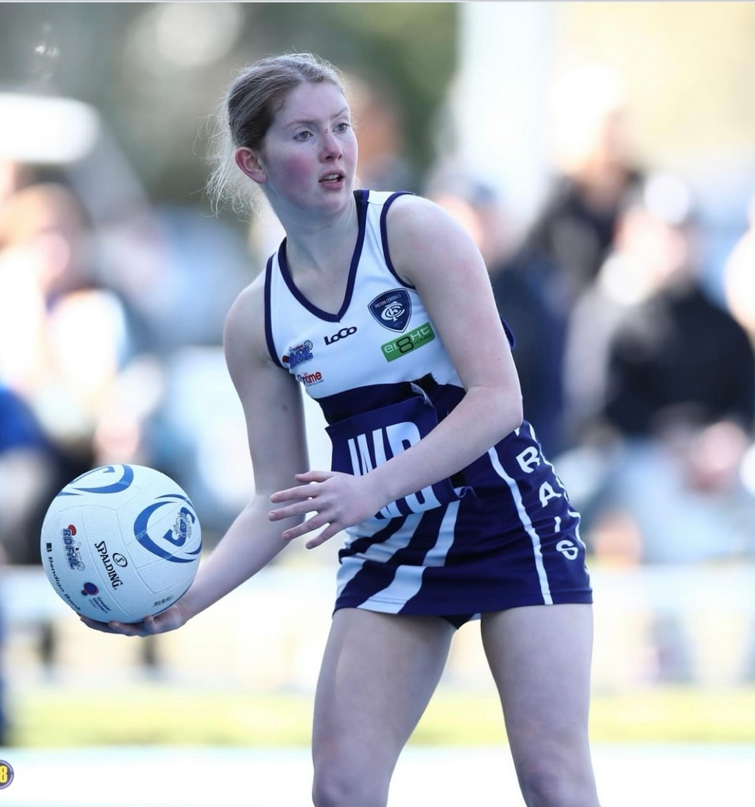 Mackenzie holding a netball on a court. 