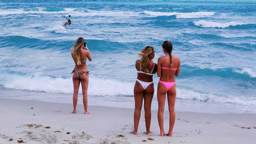 Girls stand on a beach in Miami