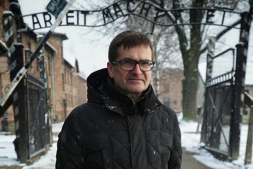 Andrzej Kacorzyk near the world-famous "Arbeit Macht Frei" sign.