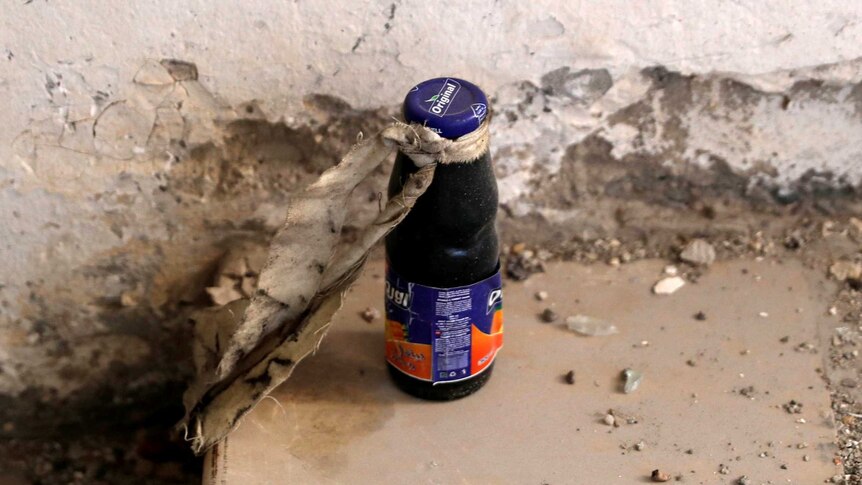 An unexploded bomb inside a juice bottle is pictured near the bunker of the Islamic State militants.