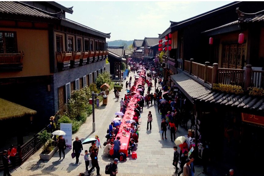 a long red table runs through the streets of a chinese town