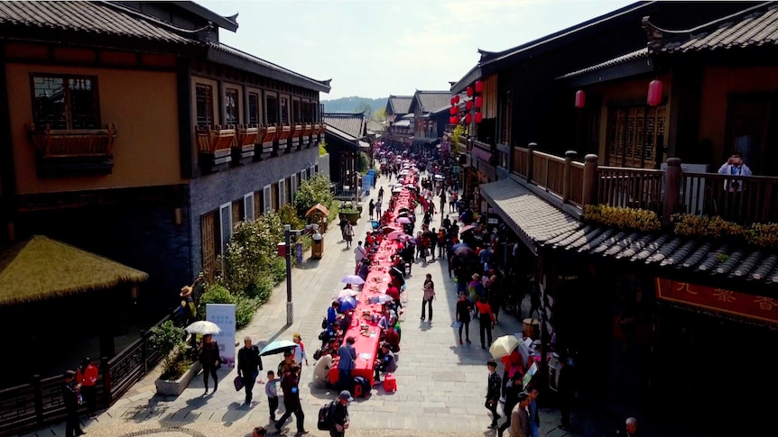 a long red table runs through the streets of a chinese town