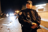 A policeman stands guard as police and firefighters are hunting for a tiger on the loose near Paris, November 13, 2014