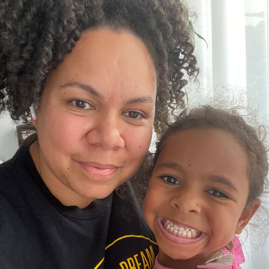 A woman and her daughter smile. 