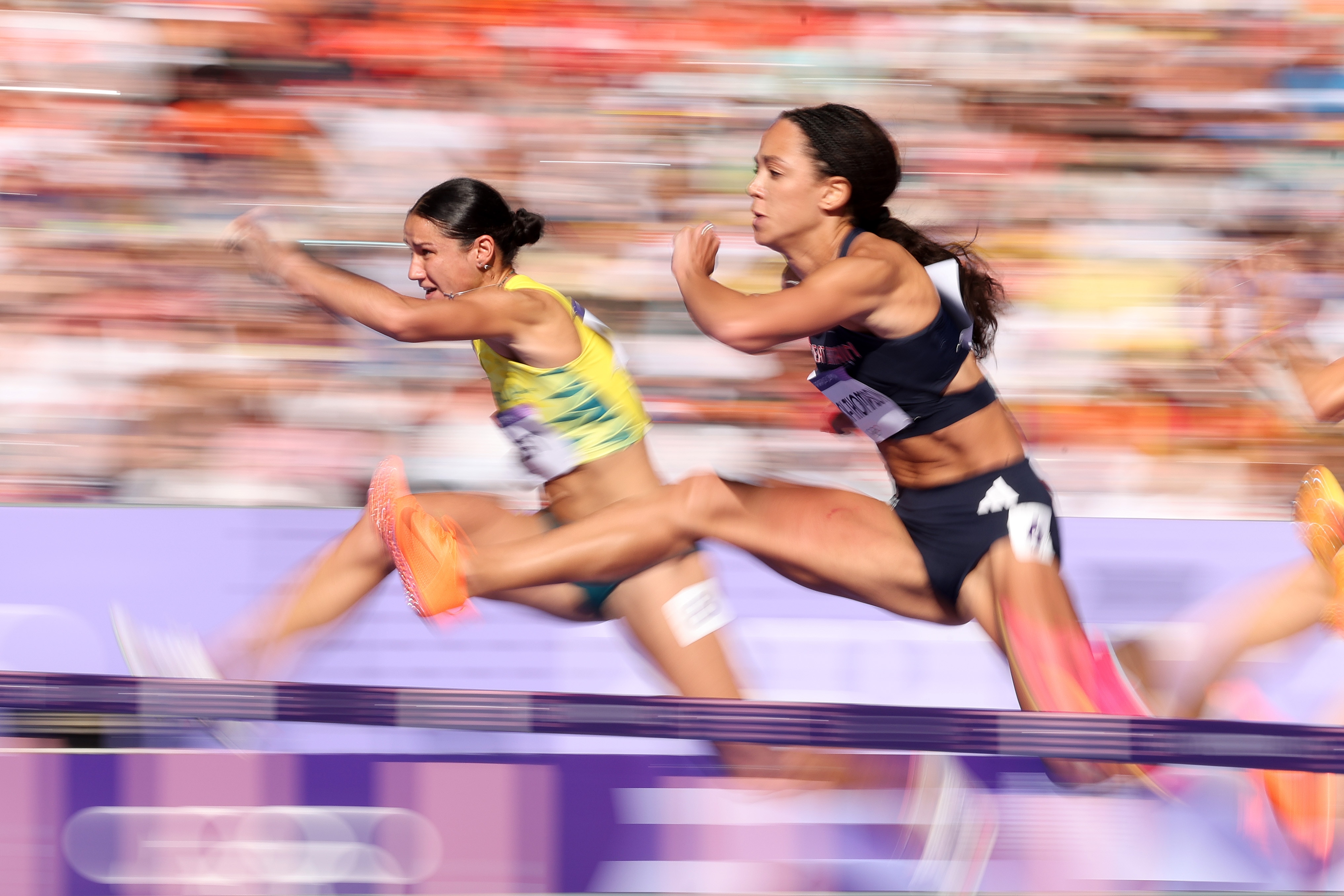 Tori West and Katarina Johnson-Thompson clear hurdles in the 100m hurdles in the Paris Olympics heptathlon.