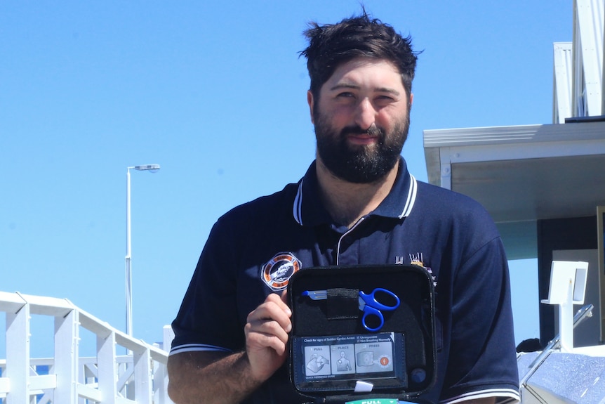 A young bloke on a jetty with a defibrillator