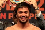 All smiles ... Manny Pacquiao poses on the scale during his official weigh-in at MGM Grand Garden Arena