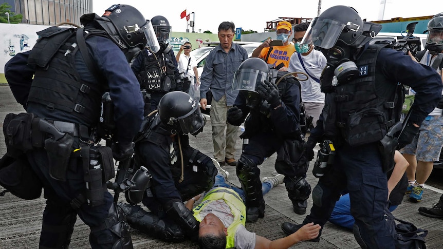 A cameraman lies injured after riot police fire tear gas on protesters outside the Legislative Council in Hong Kong.