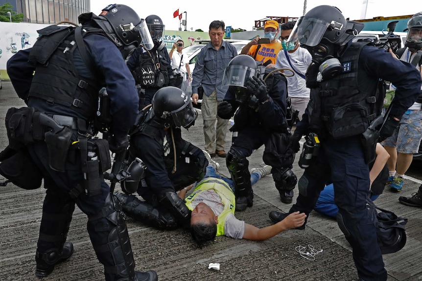 A cameraman lies injured after riot police fire tear gas on protesters outside the Legislative Council in Hong Kong.