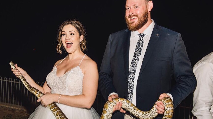 Wedding couple holding snake